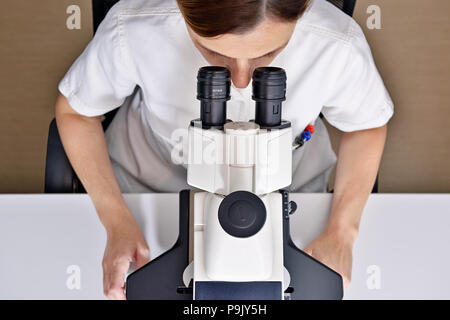 Wissenschaftlerin mit einem Mikroskop im Labor Stockfoto