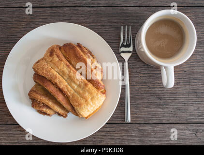 Blick von oben auf die Franzbroetchen Gebäck auf Platte auf rustikalen Holztisch Stockfoto