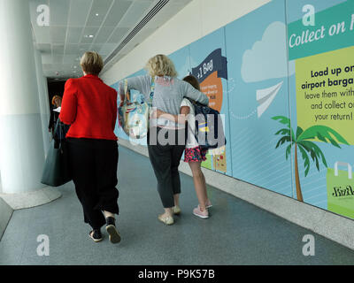 Passagiere vorbei gehen. Die Werbung auf Wände ihren Weg mit Ihrer Flüge am Flughafen Manchester Klemme 3 verbinden Stockfoto