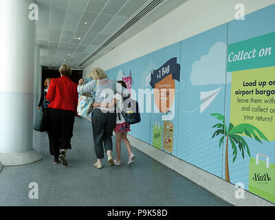 Passagiere vorbei gehen. Die Werbung auf Wände ihren Weg mit Ihrer Flüge am Flughafen Manchester Klemme 3 verbinden Stockfoto