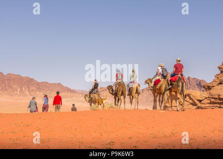 WADI RUM WÜSTE, Jordanien - April 30, 2016: Touristen reiten auf Kamelen reiten in Wadi Rum Wüste in Jordanien. Stockfoto