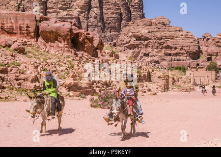 PETRA, Jordanien - April 30, 2016: einer Beduinenfamilie reiten auf dunke Stockfoto