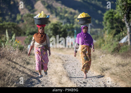 SEMBALUN LAWANG, Indonesien - 26. AUGUST 2017: Nicht identifizierte Frauen eine unbebaute Straße in Sembalun Lawang. Stockfoto