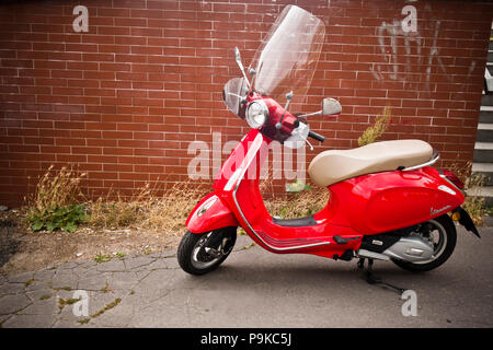 Red scooter Vespa Primavera auf der Straße geparkt Stockfoto