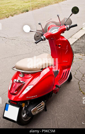 Red scooter Vespa Primavera auf der Straße geparkt Stockfoto