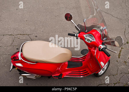 Red scooter Vespa Primavera auf der Straße geparkt Stockfoto