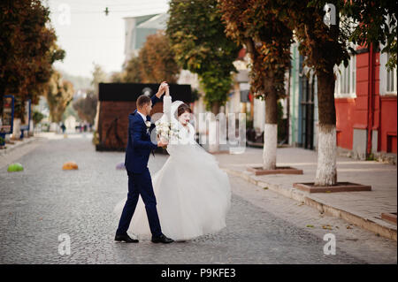 Atemberaubende Hochzeit paar Wandern und Spaß auf der alten Straße im Herbst. Stockfoto