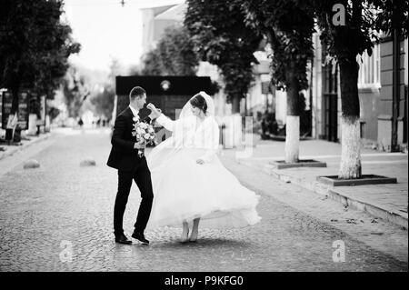 Atemberaubende Hochzeit paar Wandern und Spaß auf der alten Straße im Herbst. Stockfoto