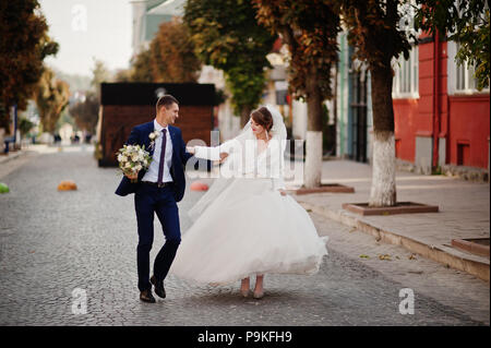 Atemberaubende Hochzeit paar Wandern und Spaß auf der alten Straße im Herbst. Stockfoto