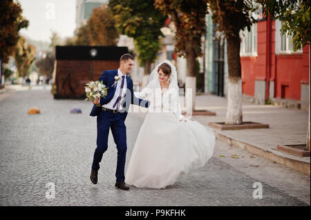 Atemberaubende Hochzeit paar Wandern und Spaß auf der alten Straße im Herbst. Stockfoto