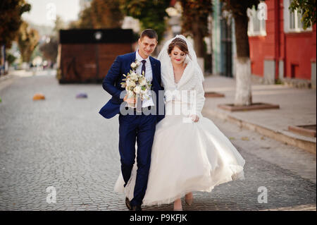 Atemberaubende Hochzeit paar Wandern und Spaß auf der alten Straße im Herbst. Stockfoto