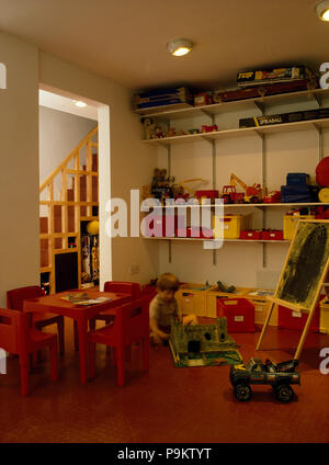 Kleiner Junge spielt in sechziger Jahre Spielzimmer Stockfoto