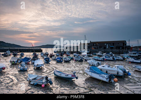 Lyme Regis, Dorset, Großbritannien. Juli 2018. UK Wetter: Weiche, gedämpfte Sonnenaufgangsfarben am Morgenhimmel spiegeln sich bei Ebbe im historischen Cobb Harbour in Lyme Regis. Quelle: DWR/Alamy Live News Stockfoto