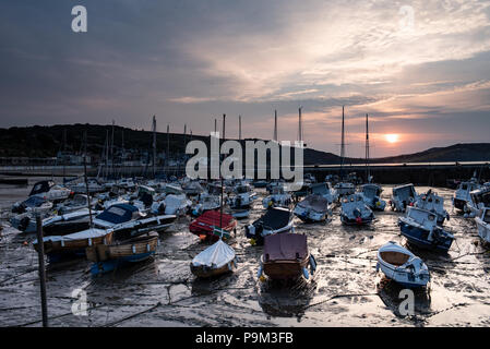 Lyme Regis, Dorset, Großbritannien. Juli 2018. UK Wetter: Weiche, gedämpfte Sonnenaufgangsfarben am Morgenhimmel spiegeln sich bei Ebbe im historischen Cobb Harbour in Lyme Regis. Quelle: DWR/Alamy Live News Stockfoto