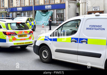 Maidstone, Kent, Großbritannien. 19. Juli 2018. Mehrere Polizeiautos, ein Krankenwagen und Forensik Ermittlungsgruppe umgeben die Royal Bank of Scotland Niederlassung in Maidstone High Street nach dem Tod eines rough Sleeper. Ein großes Jubiläum Platz im Zentrum der Stadt wurde nach der Entdeckung des Körpers in der Tür der RBS-Filiale heute Morgen abgesperrt. Die Polizei war um 8:45 Uhr - Der Tod ist nicht als verdächtig. Credit: PjrNews/Alamy leben Nachrichten Stockfoto