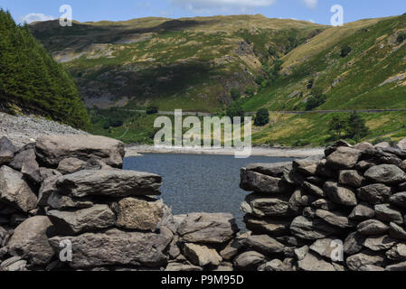 Haweswater, Cumbria UK. Juli 2018. Ein Fenster mit Blick auf Haweswater in einem Gebäude, das abgerissen wurde, um Platz für das Wasser zu machen, das heute das Tal füllt. Mardale Green wurde evakuiert, um Platz für das Haweswater Reservoir zu schaffen, das in den 1930er Jahren gefüllt wurde, um Trinkwasser nach Manchester über 80 Meilen entfernt zu pumpen. Bild vom 19.07.2018. Quelle: Stop Press Media/Alamy Live News Stockfoto