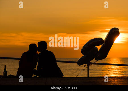 Aberystwyth Wales UK, Donnerstag, 19. Juli 2018 UK Wetter: Menschen sind ab, da sie einen 21. Geburtstag sitzen auf der Promenade bei Sonnenuntergang in Aberystwyth an der Westküste von Wales feiern. Die Hitzewelle ist so eingestellt, dass es weiter, mit Temperaturen erwartet 30°C wieder bis Ende der Woche Foto: Keith Morris Credit: Keith Morris/Alamy leben Nachrichten Stockfoto