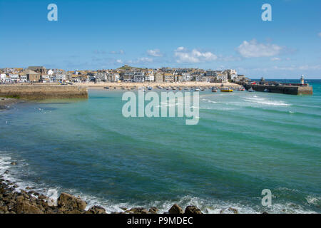 Blick auf den Hafen von St Ives in der Ferne mit ihren weißen Leuchtturm auf smeatons Pier, St Ives, Cornwall, Großbritannien Stockfoto