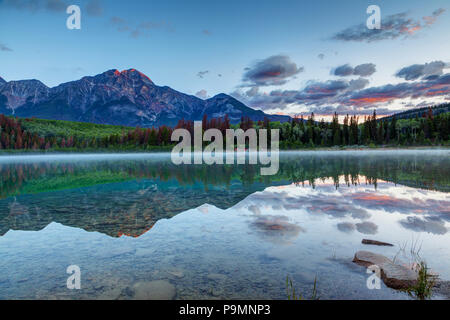 Am frühen Morgen Sonnenaufgang an Patricia Lake mit dem goldenen sonnenbeschienenen Pyramide Berg im Hintergrund und misty Nebel auf der Oberfläche des Wassers. Wide Angle Shot Stockfoto