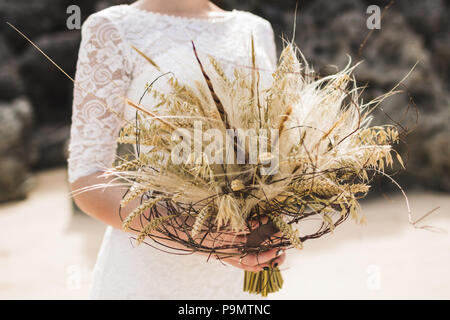 Wedding Bouquet mit getrockneten Blumen und ährchen Boho style in Bräute Hände Stockfoto