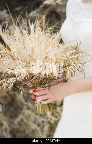 Wedding Bouquet mit getrockneten Blumen und ährchen Boho style in Bräute Hände Stockfoto