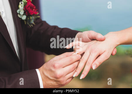 Tragen ring Bräutigam der Braut hand auf Hochzeit close-up Stockfoto