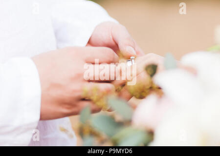 Tragen ring Bräutigam der Braut hand auf Hochzeit close-up Stockfoto