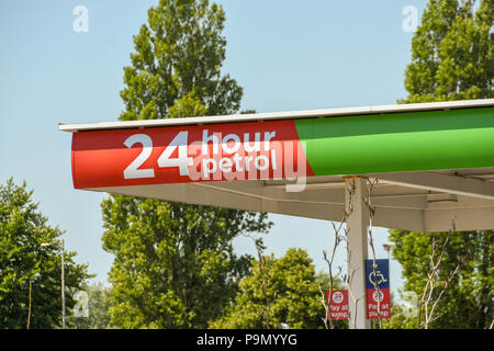 Schild an der Spitze einer Tankstelle Vordach, Es ist rund um die Uhr geöffnet Stockfoto