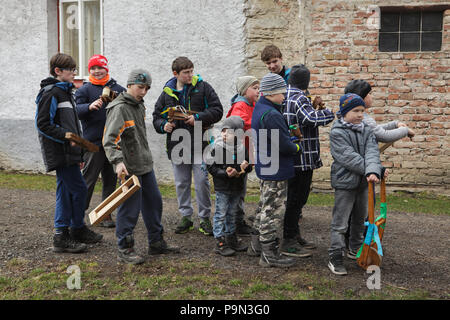 Schöne traditionelle Ostern Prozession bekannt als Vodění Jidáše (Judas) im Dorf Stradouň in Pardubice, Tschechische Republik. Jungen mit hölzernen Ratschen nehmen an der Prozession am 31. März 2018. Am frühen Morgen des Karsamstag, der älteste Teenager in das Dorf liegt in einem lächerlichen Stroh Anzug gekleidet. Er soll Judas Iskariot auf diese Weise durchzuführen. Das Tragen dieser obskuren Outfit, hat er März durch das Dorf von Haus zu Haus von anderen Jungen, die Twist hölzernen Ratschen und ein Lied über Judas, der seinen Meister zu den Juden, sammeln Süßigkeiten und Eier von verraten Singen begleitet Stockfoto