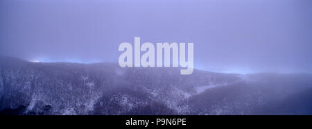 Schnee hinunter auf die Felsen und Wälder in Victoria's High Country. Stockfoto