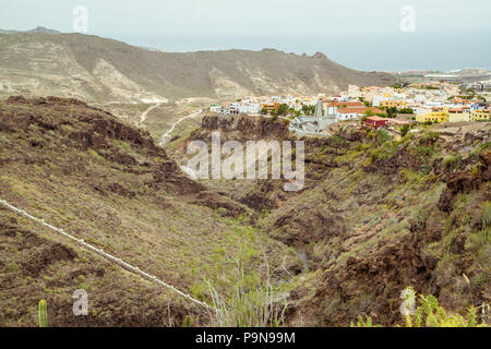 Blick auf den Barranco del Infierno (Hell's Gorge), das Tal oder Canyon mit der Stadt Adeje oben mit hellen, freundlichen Gebäuden, Atlantik, grün Stockfoto