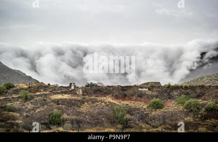 Bemerkenswerte Landschaft ornographic Wasserfall Wolken sich über die leeward Hang der Berge nördlich von Santa Cruz, Teneriffa. Ungewöhnliche Natur. Stockfoto