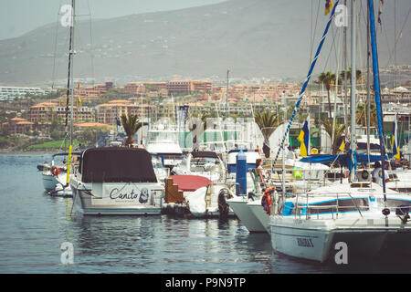 Boote, Yachten und Katamarane in Puerto Colón Marina vor der Küste von La Calima sand und Dunst verborgen, von Hotels, Apartments und einen Hügel Stockfoto