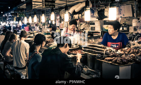 Seoul, Südkorea - 11. Mai 2017: Die Kunden genießen die traditionelle koreanische Lebensmittel bei GwangJang Markt in der Nacht. Stockfoto