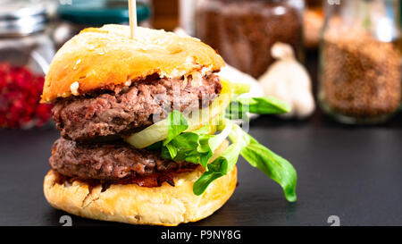 Fastfood Konzept Hausgemachte Hamburger auf schwarzem Schiefer Platte mit Kopie Raum Stockfoto