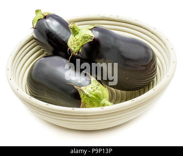 Ganze drei Eierfrüchte (Auberginen) in Rattan Schüssel auf weißem Hintergrund Stockfoto
