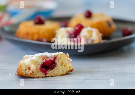 Scheiben frischen iced Biskuitteig mit Kirschen auf rustikalen hölzernen Hintergrund Stockfoto
