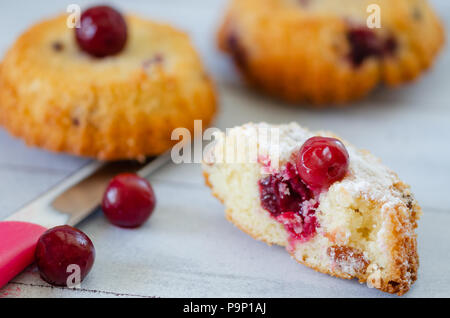 Scheiben frischen iced Biskuitteig mit Kirschen auf rustikalen hölzernen Hintergrund Stockfoto