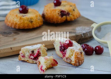 Scheiben frischen iced Biskuitteig mit Kirschen auf rustikalen hölzernen Hintergrund Stockfoto