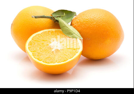 Orangen auf weißem Hintergrund zwei ganze Eine mit grünen Blättern und eine Hälfte isoliert Stockfoto