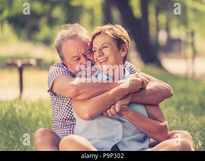 Glücklich lächelnde senior Paar in Liebe, Entspannung, Tanz und Spaß in den Park. Gemeinsam stark, Ruhestand, glückliches Leben Konzept. Stockfoto