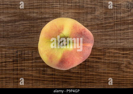 Eine frische reife Saturn Pfirsich flatlay auf braunem Holz Hintergrund Stockfoto