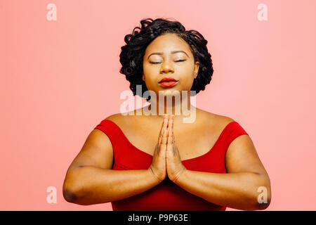 Inneren Frieden/Junge Frau in Rot, auf rosa Hintergrund isoliert Stockfoto