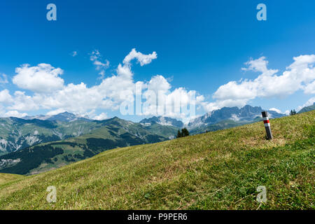 Idyllische Berglandschaft mit Wanderweg und Wegweiser im Vordergrund und eine großartige Aussicht Stockfoto