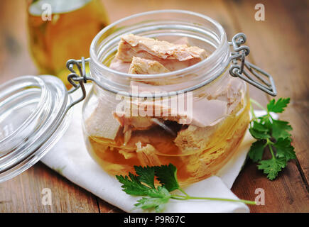 Thunfisch mit Petersilie in einem Glas auf hölzernen Tisch Stockfoto