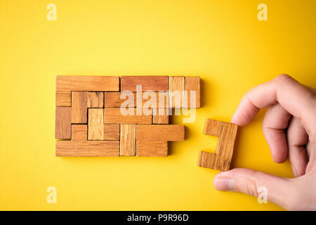 Frau hand Holzklötze arrangieren Stapeln für Schlichten Aufgabe. Konzept der Problem- und Erfolg planen zu lösen. Stockfoto
