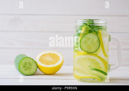 Detox erfrischende Wasser mit Zitrone und Gurke in ein Glas Schale auf einem hölzernen Hintergrund Stockfoto