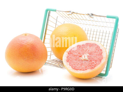 Rote Grapefruits aus einem Warenkorb auf weißem Hintergrund zwei ganze und eine halbe isoliert Stockfoto