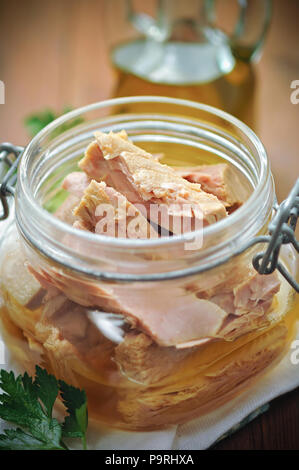 Thunfisch mit Petersilie in einem Glas auf hölzernen Tisch Stockfoto