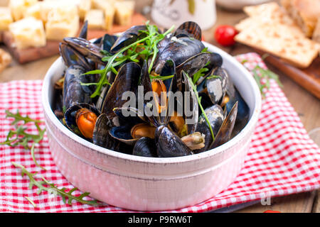 Müsli in einem weißen Keramik Schüssel, auf einem roten Serviette. Auf einer hölzernen Hintergrund Stockfoto